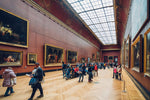 Load image into Gallery viewer, Tourists admiring some renaissance era paintings in the Louvre museum.
