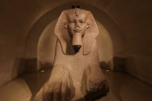 A large Egyptian statue inside the Louvre.