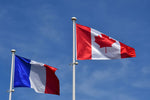 Load image into Gallery viewer, The Canadian and French flag flying together in Normandy, France.
