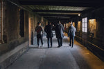 Load image into Gallery viewer, Four people tour a cognac cellar in Cognac, France.
