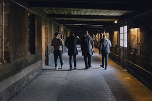 Four people tour a cognac cellar in Cognac, France.