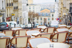 Load image into Gallery viewer, Chairs at an empty cafe in the Montmartre district of Paris.
