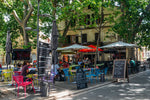 Load image into Gallery viewer, A cafe in a treelined square in Arles, France.  
